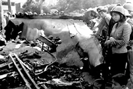 Militantes de Hanoi al lado del resto de un B-52 derribado (Fuente: VNA)