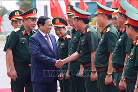 El primer ministro Pham Minh Chinh y las autoridades de la Corporación de Construcción Truong Son. (Fuente:VNA)