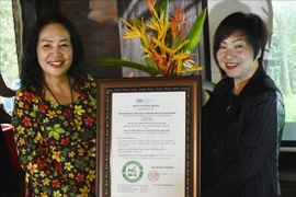 Ngô Kim Trang, subjefa del Instituto de Investigación Aplicada e Innovación en Empresas, entrega el certificado de estación de cero emisiones netas al complejo Suoi Rao Ecolodge. (Fuente:VNA)