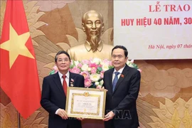 El presidente parlamentario Tran Thanh Man (derecha) entrega la insignia por 40 años de membresía del PCV a Nguyen Duc Hai, miembro del Comité Central del Partido y miembro del Comité de asuntos partidistas de la AN y vicepresidente del Parlamento. (Fuente:VNA)