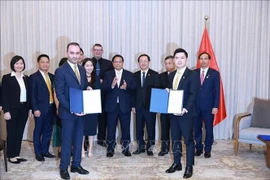 El primer ministro Pham Minh Chinh y funcionarios presencian la entrega de un memorando de entendimiento sobre cooperación en materia de deportes y entretenimiento entre T&T y JTA. (Foto: VNA)