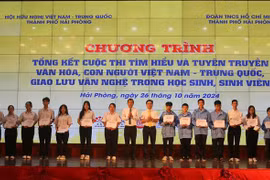 El comité organizador entrega obsequios a los estudiantes con excelentes logros académicos vietnamitas y chinas en Hai Phong. (Fuente: VNA)