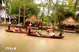 Los turistas experimentan remar en el río en la aldea turística My Khanh, en la ciudad de Can Tho. (Fuente: VNA)