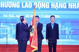 El presidente de la Asamblea Nacional, Tran Thanh Man, coloca la Orden del Trabajo de primera clase en la bandera tradicional de la Confederación General del Trabajo de Vietnam. (Fuente: VNA)