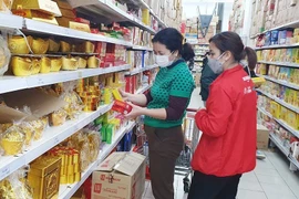 Los consumidores eligen productos en el supermercado Big C Long Bien, distrito de Long Bien. (Fuente: hanoimoi.vn)