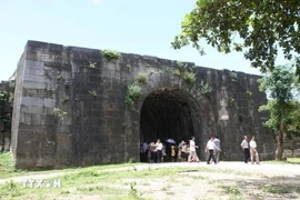 Los turistas visitan la puerta de piedra en el norte de la ciudadela de la dinastía Ho. (Foto: VNA)