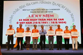 El Comité del Frente de la Patria de Ciudad Ho Chi Minh entrega becas a representantes de niños víctimas del Agente Naranja/Dioxina (Fuente: VNA)