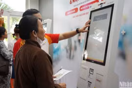 Se enseña a una paciente probar el sistema Quiosco de Salud inteligente en el Hospital de Da Nang. (Fotografía: Nhan Dan) 