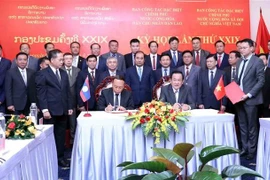 El viceministro de Defensa y jefe del grupo de trabajo vietnamita, el teniente general Vo Minh Luong (derecha), y el viceministro de Defensa y jefe del grupo de trabajo de Laos, el teniente general Thongloi Silivong, firman el acta de la reunión. (Foto: VNA)