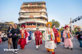 Cientos de personas vestidas con trajes antiguos desfilan por las principales calles de Hanoi 