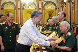  El presidente To Lam entrega una fotografía del Presidente Ho Chi Minh al mayor general Vo So, de 96 años, jefe del Comité de Enlace de Veteranos de la División 305 de Caballería Aérea y Fuerzas Especiales. (Fuente: VNA)