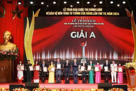 El secretario general del Partido Comunista y presidente de Vietnam, To Lam, y el miembro permanente del Secretariado del Comité Central del Partido, Luong Cuong, entregan premios de primer lugar a los autores. (Fuente: VNA)