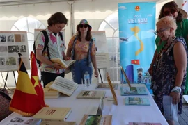Los visitantes prestan atención al libro del fallecido secretario general del Partido Comunista de Vietnam, Nguyen Phu Trong. (Foto: VNA)