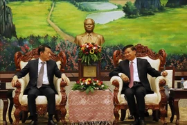 El secretario general del Partido Popular Revolucionario y presidente de Laos, Thongloun Sisoulith (derecha), recibe al ministro de Seguridad Pública de Vietnam, coronel general Luong Tam Quang. (Foto: VNA)