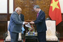 El embajador Orlando Nicolás Hernández Guillén (izquierda) entrega cartas de felicitación de los líderes cubanos al presidente de Vietnam, To Lam. (Foto: VNA)