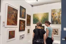 El rincón de pintura lacada del artista Phuong Binh atrae a muchos espectadores. (Foto: VNA)