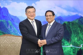 El primer ministro Pham Minh Chinh (D) y el vicepresidente del Comité Permanente de la Asamblea Popular Nacional (APN) de China, Zhang Qingwei. (Foto: VNA)