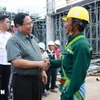 El primer ministro Pham Minh Chinh con los trabajadores que construyen el proyecto del Aeropuerto Internacional de Phu Quoc. (Foto: VNA)