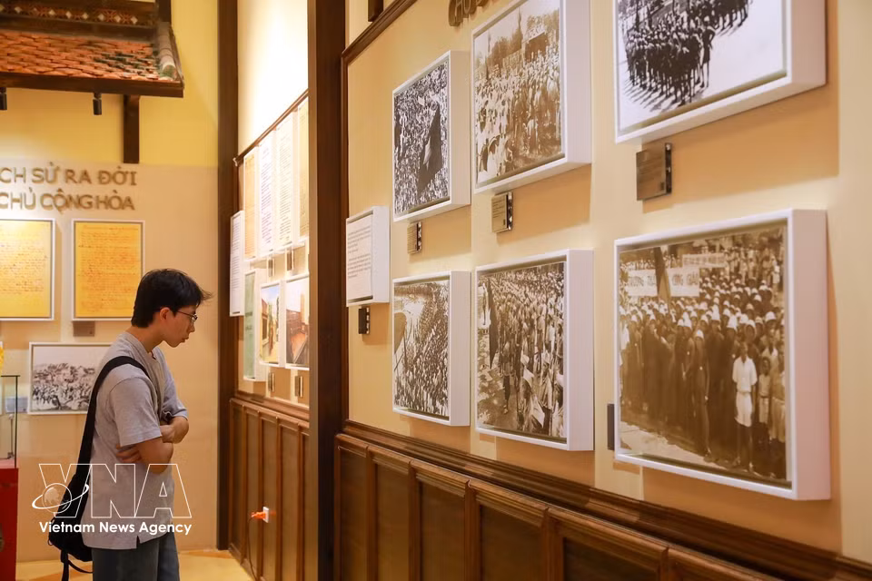 Visitantes consultan información sobre los objetos expuestos y las historias relacionadas con la historia del lugar. Foto: Khanh Hoa – VNA