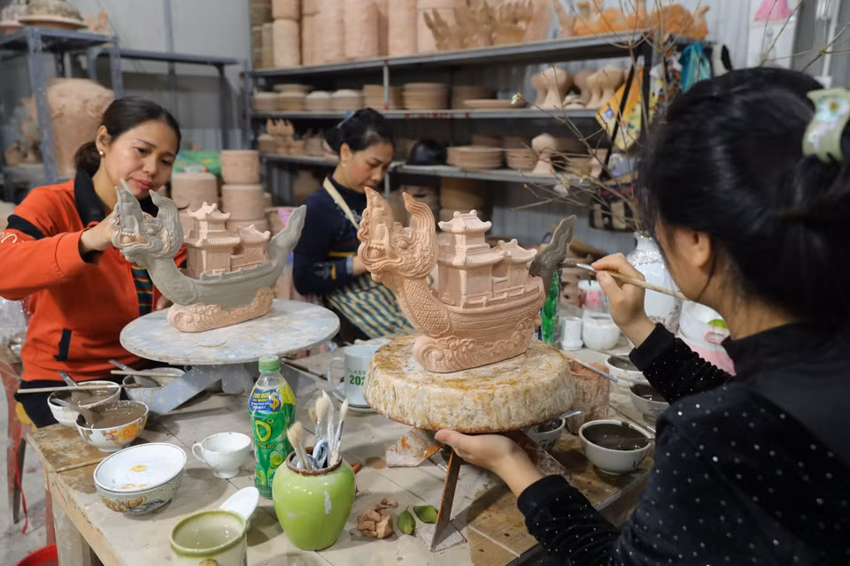 Aplicando esmalte sobre la cerámica "Ngu long khanh hoi" en el taller del artesano Nguyen Trong Nghia en el pueblo de cerámica Bat Trang. Foto: VNA