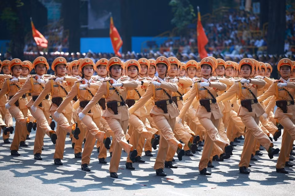 Las mujeres policías de tránsito marchan frente a la tribuna. Foto: VNA