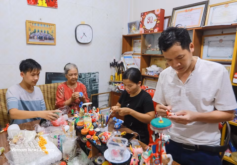 Tres generaciones de la familia del artesano Dang Van Hau mantienen y transmiten el oficio tradicional de elaboración de “to he”. Foto: Khanh Hoa – VNA