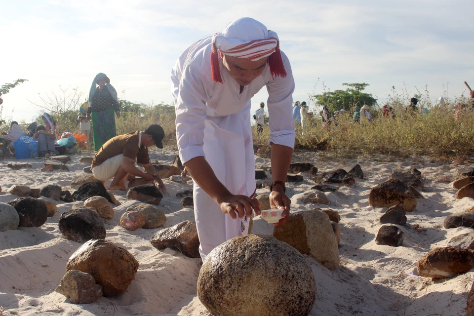 El ritual de purificación de las tumbas antes de leer los rezos. Foto: VNA