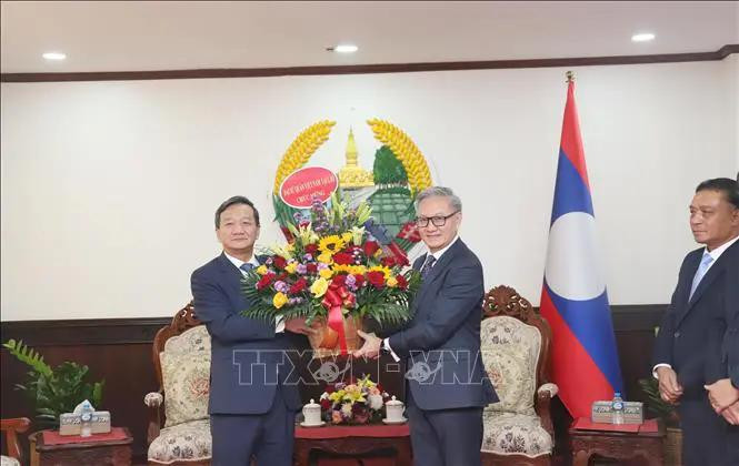 El embajador de Vietnam en Laos, Nguyen Minh Tam, entregó flores para felicitar el 49º aniversario del Día Nacional de Laos al ministro de Relaciones Exteriores de Laos, Thongsavanh Phomvihane. (Fuente: VNA)