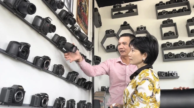 A visitor learns about the cameras on display at Like Coffee and Tea on Le Hong Phong Street, Nga Bay City, Hau Giang Province, southern Vietnam. (Photo: Tuoitre.vn)