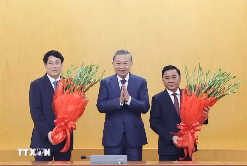 El secretario general del Partido Comunista de Vietnam, To Lam, entrega flores al miembro del Buró Político y presidente. Luong Cuong. y el miembro del Buró Político y permanente del Secretariado del Comité Central del Partido. (Foto: VNA)