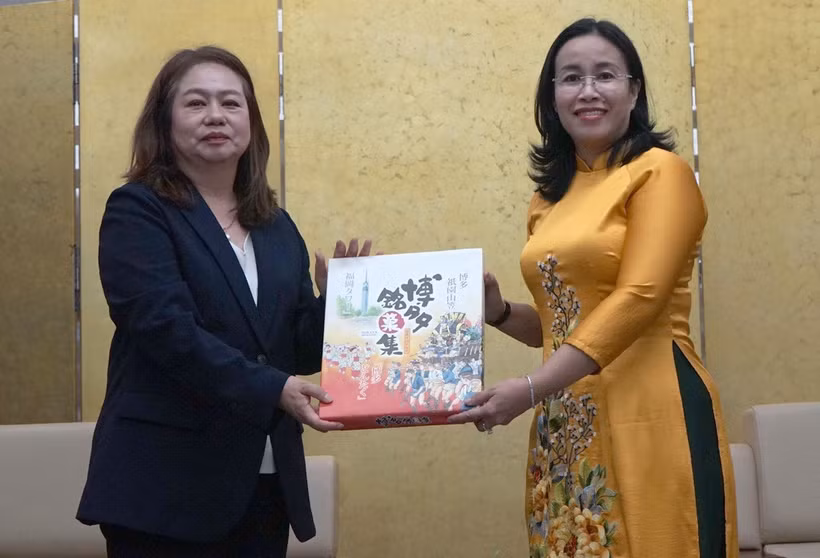 La vicepresidenta del Comité Popular de la ciudad vietnamita de Da Nang, Nguyen Thi Anh Thi, entrega obsequio a Satomi Iwashige, vicerrectora a cargo de estrategia y relaciones internacionales de la Universidad de la prefectura japonesa de Nagasaki. (Foto: VNA)