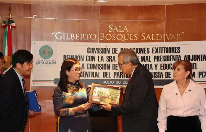 Dinh Thi Mai, subjefa de la Comisión de Propaganda, Educación y Movilización de Masas del Comité Central del Partido Comunista de Vietnam, entrega un recuerdo al diputado Pedro Vázquez, presidente de la Comisión de Relaciones Exteriores de la Cámara de Diputados de México. (Foto: VNA)