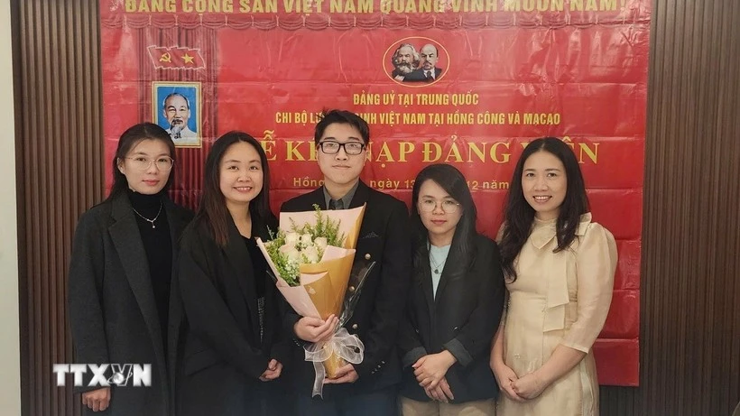 Nguyen Thi Xuan Hue (segunda desde la izquierda), estudiante de doctorado en Lingüística Inglesa Aplicada de la Universidad de Macao (China), en una ceremonia de admisión de nuevos miembros del partido. (Foto: VNA)