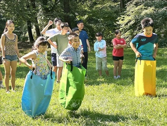 Los niños participan en los juegos populares en el festival. (Foto: VNA)
