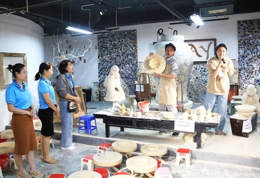 Turistas observan una exhibición de cerámica tradicional en la aldea artesanal de Bat Trang. (Foto: hanoimoi.vn)