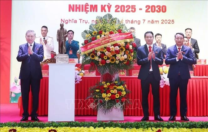 El secretario general del Partido Comunista de Vietnam, To Lam (izquierda) entrega una cesta de flores para felicitar a la asamblea del Comité partidista de la comuna de Nghia Tru del período 2025-2030. (Foto: VNA)