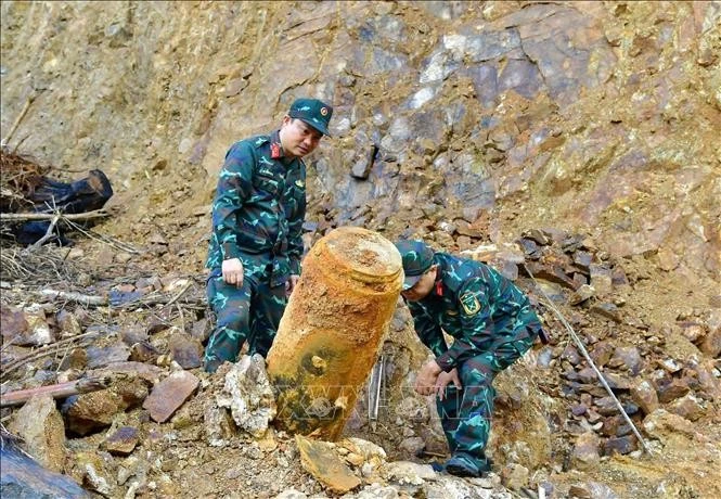 Las autoridades trasladan la bomba al lugar de la detonación. (Foto: VNA)