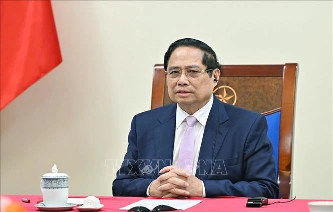 El primer ministro de Vietnam, Pham Minh Chinh, sostiene una llamada telefónica con su homólogo malasio, Anwar Ibrahim. (Foto: VNA)