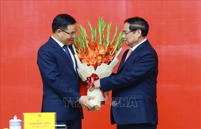 El primer ministro de Vietnam, Pham Minh Chinh, entrega la decisión de nombrar a Le Manh Hung, como ministro interino de Industria y Comercio. (Foto: VNA)