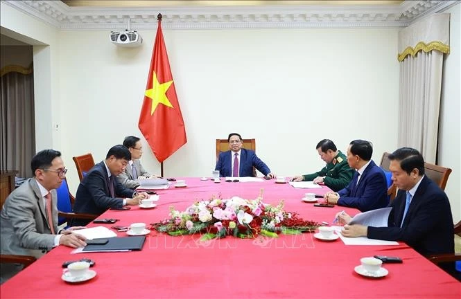 El primer ministro de Vietnam, Pham Minh Chinh, sostiene una conversación telefónica con su homólogo de Malasia, Anwar Ibrahim. (Foto: VNA)