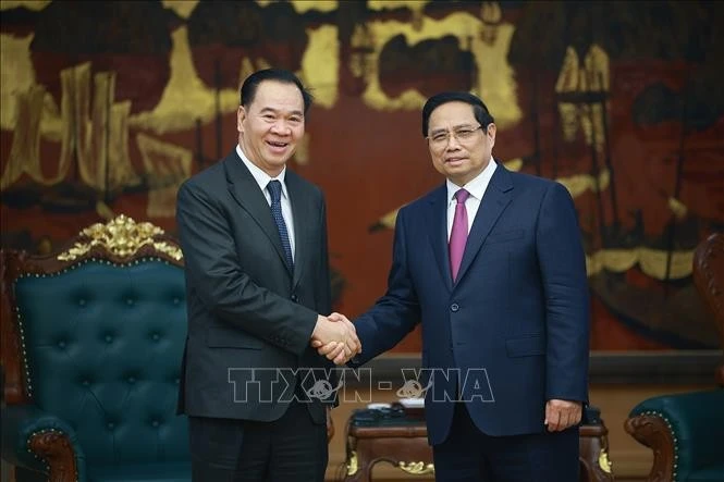 El primer ministro vietnamita, Pham Minh Chinh, recibe al ministro de Educación y Deportes de Laos, Thongsalith Mangnormek (Fuente: VNA)