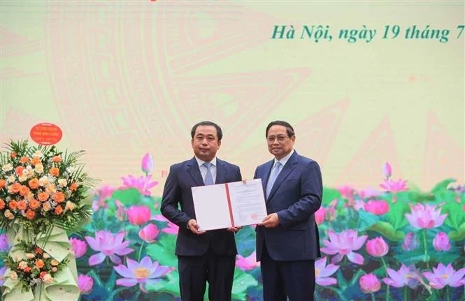 El primer ministro Pham Minh Chinh entrega la decisión oficial de nombrar a Tran Duc Thang como ministro interino del Ministerio de Agricultura y Medio Ambiente. (Foto: VNA)