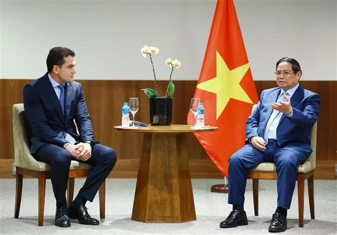 El primer ministro vietnamita, Pham Minh Chinh, (derecha) conversa con representantes del Grupo JBS, una de las principales empresas de procesamiento de alimentos a nivel mundial, con sede en Brasil y presencia en 24 países y territorios. (Fuente: VNA)