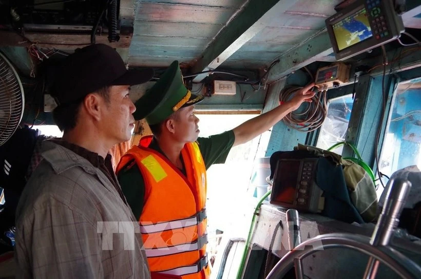 Los guardias fronterizos de Dong Thap inspeccionan el funcionamiento del sistema de monitoreo de embarcaciones en un barco pesquero. (Foto: VNA)