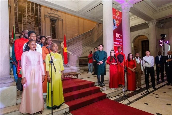 Cantando los himnos nacionales de ambos países durante la celebración. (Foto: VNA) 