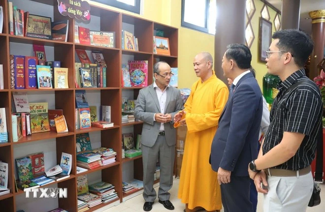 El abad de la Pagoda de Phat Tich en Vientián presenta la estantería a visitantes. (Foto: VNA)
