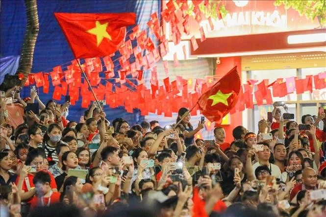 Los hanoiyense dan la bienvenida a los bloques que transitan por la calle Trang Tien durante el ensayo estatal del desfile y la marcha del evento A80. (Foto: VNA)
