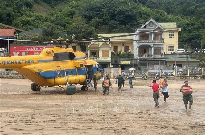 Un helicóptero entrega suministros de socorro a los habitantes locales (Foto: VNA)