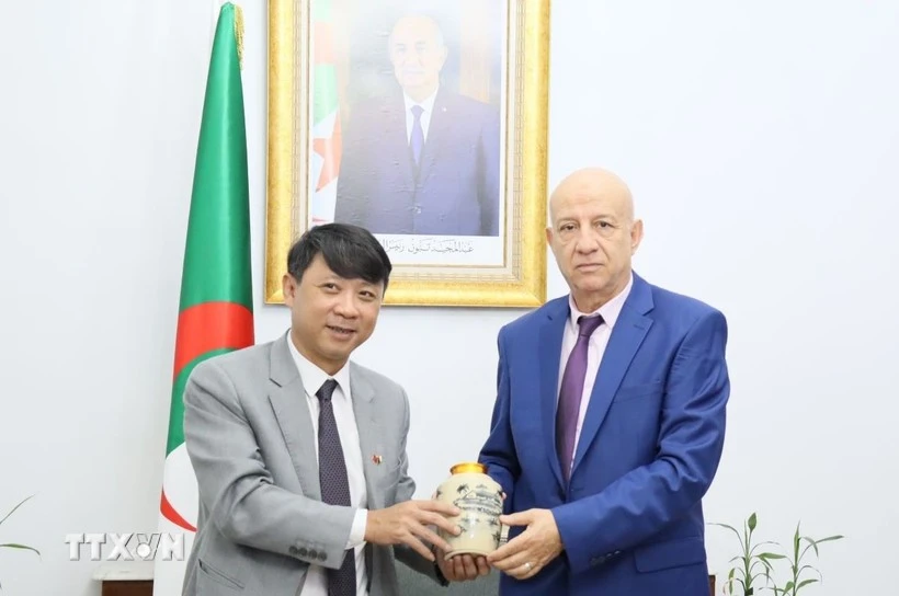 El subeditor en jefe de la Revista Comunista de Vietnam Nguyen Ngoc Ha entrega regalo al secretario general del Frente de Liberación Nacional de Argelia (FLN), Abdelkrim Benmbarek. (Foto: VNA)