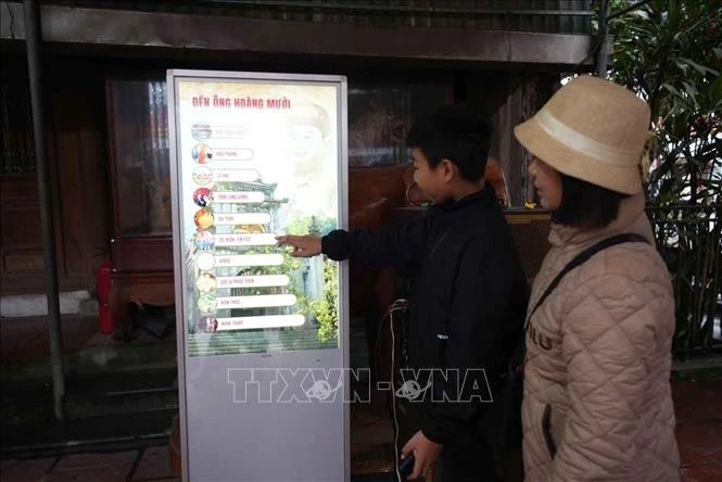 Los turistas utilizan el sistema de quioscos para obtener información sobre las reliquias del templo Ong Hoang Muoi (Nghe An). Foto: VNA